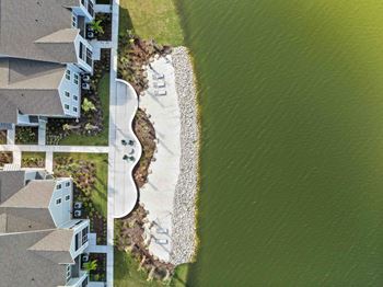 A beachfront property with a house and a sandy beach.
